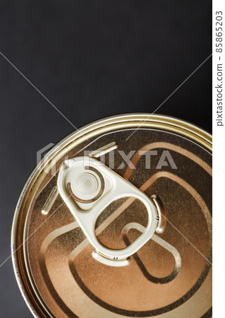 The lid of a metal tin can on a black background 85865203
