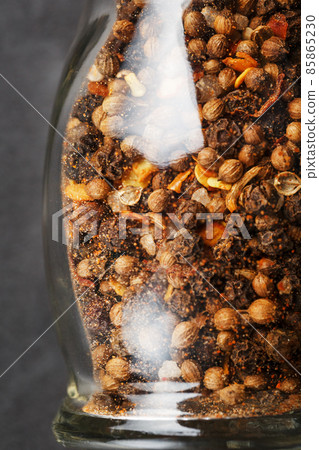 A mixture of seasonings, spices and herbs in a glass mill Close-up. 85865230