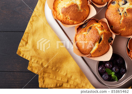 A group of mafins with berries and chocolate on a dark wooden background. FLat lay. Top view. 85865462