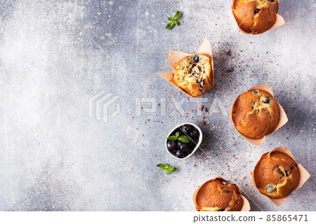 A group of muffins with blueberries and chocolate on a light background. Flat lay. Top view. 85865471