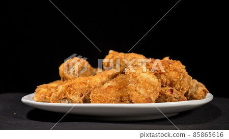 Cool beautiful fresh juicy cooked chicken wings in breading. Buffalo wings spread on food in white plate. Cooking with deep fryer fry machine. 85865616
