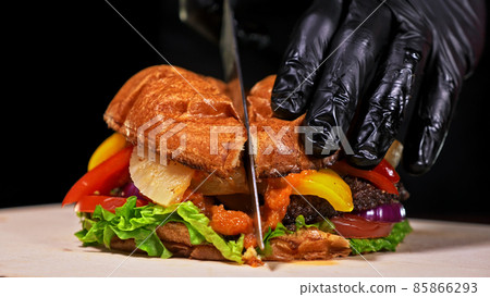 Cut craft burger is cooking. Consist: red sauce salsa, lettuce, red onion, pickle, cheese, chilli green pepper, air bun and marbled meat beef. 85866293