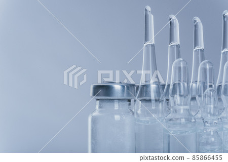 Glass medical ampoule vial for injection. Medicine is dry white drug penicillin powder or liquid with of aqueous solution in ampulla. Close up. Glass medical ampoule vial for injection. Medicine is dry white drug penicillin powder or liquid with of aqueous solution in ampulla. Close up. 85866455