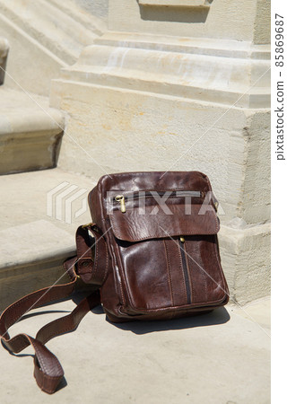 Outdoor photo of a brown leather Messenger bag. Outdoor photo of a brown leather Messenger bag. 85869687