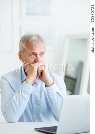 Frustrated employee. Work crisis. Unemployment problem. Thoughtful unhappy mature man freelancer thinking at laptop at home office workspace. Frustrated employee. Work crisis. Unemployment problem. Thoughtful unhappy mature man freelancer thinking at laptop at home office workspace. 85870721