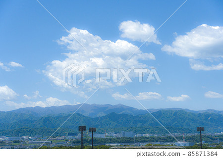 Spring countryside with mountains and big clouds Spring countryside with mountains and big clouds 85871384