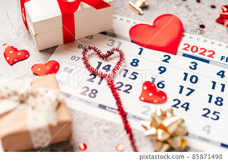 Flat lay of Valentines day calendar composition. Top view Gifts, paper, hearts confetti, ribbon on grey table background. 14th February love concept 85871498