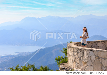 Young tourist woman enjoying view of Kotor bay in Montenegro in mountains Young tourist woman enjoying view of Kotor bay in Montenegro in mountains 85871557