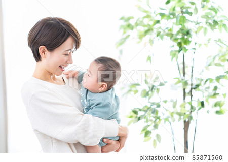 A mother holding a baby 85871560