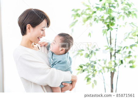 A mother holding a baby 85871561
