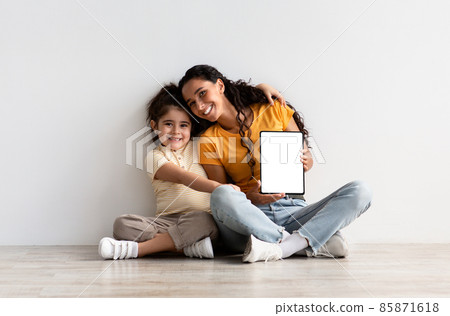 Online Ad. Happy Young Mother And Little Daughter Holding Blank Digital Tablet Online Ad. Happy Young Mother And Little Daughter Holding Blank Digital Tablet 85871618