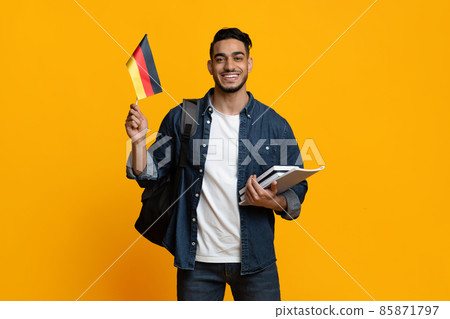 Happy arabic guy student showing flag of Germany Happy arabic guy student showing flag of Germany 85871797
