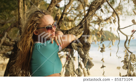 Woman walking alone on beach and relax among the tree hung with 85873104