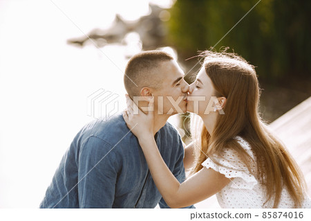 Portrait of a romantic couple kissing near the lake Portrait of a romantic couple kissing near the lake 85874016