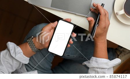 Businessman using mobile phone to check his market stock. Top view 85874117