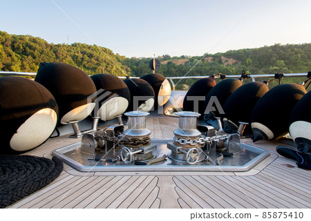 Anchor lowering and raising mechanism, Anchor Buoys and rigging on the foredeck of a luxurious yacht - selective focus Anchor lowering and raising mechanism, Anchor Buoys and rigging on the foredeck of a luxurious yacht - selective focus 85875410