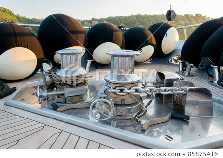 Anchor lowering and raising mechanism, Anchor Buoys and rigging on  the foredeck of a luxurious yacht - selective focus 85875416