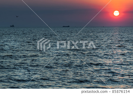 Beautiful sunset over a calm sea with a blue and orange glowing sky. 85876154
