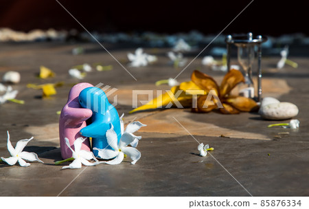 Blue and pink ceramic couple dolls hug with each other on stone background. 85876334