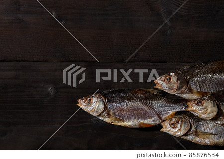 Jerky or dried salted roach, delicious clipfish on wooden background. Popular beer snack. Traditional way of preserving fish. Close up 85876534