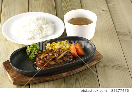 日式漢堡牛排配歐芹、胡蘿蔔玻璃、鐵盤上的玉米和蘑菇醬、清湯和米飯 85877476