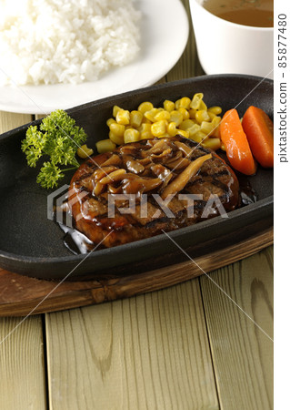 日式漢堡牛排配歐芹、胡蘿蔔玻璃、鐵盤上的玉米和蘑菇醬、清湯和米飯 日式漢堡牛排配歐芹、胡蘿蔔玻璃、鐵盤上的玉米和蘑菇醬、清湯和米飯 85877480