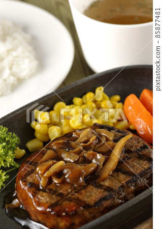 日式漢堡牛排配歐芹、胡蘿蔔玻璃、鐵盤上的玉米和蘑菇醬、清湯和米飯 85877481