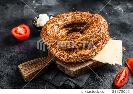 Bagel Simit or Gevrek on wooden board for cooking sandwich. Black background. Top view Bagel Simit or Gevrek on wooden board for cooking sandwich. Black background. Top view 85878005