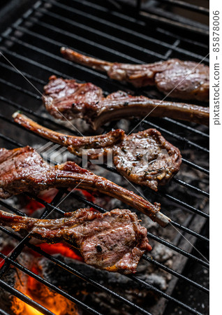Grilled lamb mutton chop steaks on barbecue, outdoor BBQ grill with fire. Top view Grilled lamb mutton chop steaks on barbecue, outdoor BBQ grill with fire. Top view 85878006