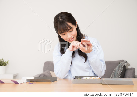 A woman who shoots a lunch box with a smartphone A woman who shoots a lunch box with a smartphone 85879414