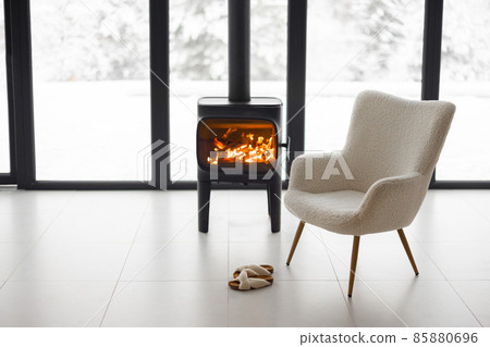 Cozy living space by the burning fireplace at snowy mountains Cozy living space by the burning fireplace at snowy mountains 85880696