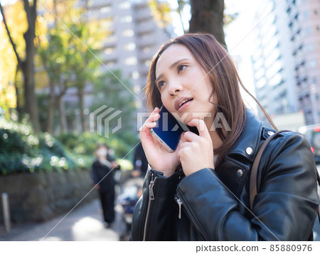 [Urban] A woman calling on her smartphone in the town 85880976
