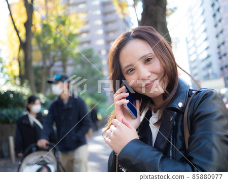 [Urban] A woman calling on her smartphone in the town 85880977