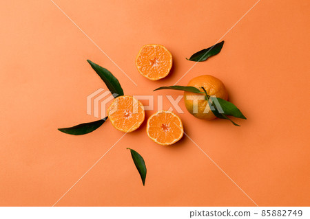 Many fresh ripe mandarin with green leaves on colored background, top view, space for text Many fresh ripe mandarin with green leaves on colored background, top view, space for text 85882749