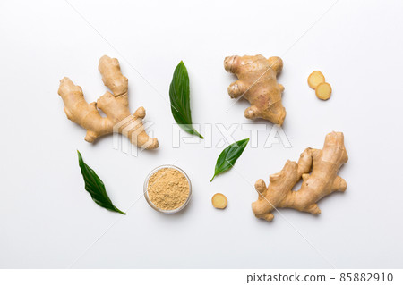 Finely dry Ginger powder in bowl with green leaves isolated on colored background. top view flat lay Finely dry Ginger powder in bowl with green leaves isolated on colored background. top view flat lay 85882910