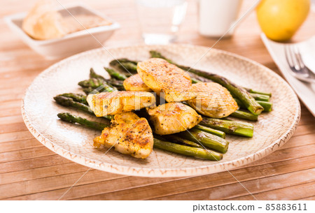 fried chicken breast pieces with asparagus on white plate fried chicken breast pieces with asparagus on white plate 85883611