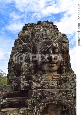 Khmer smile at Angkor ruins towering over the blue sky 85884496