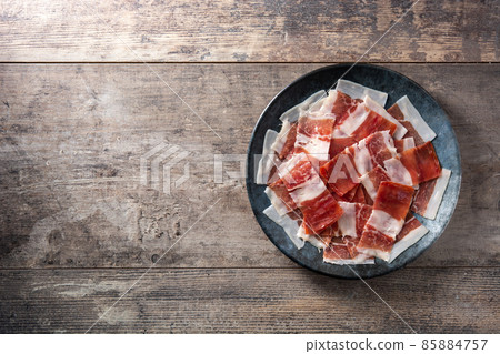 Spanish serrano ham slices on black plate Spanish serrano ham slices on black plate 85884757