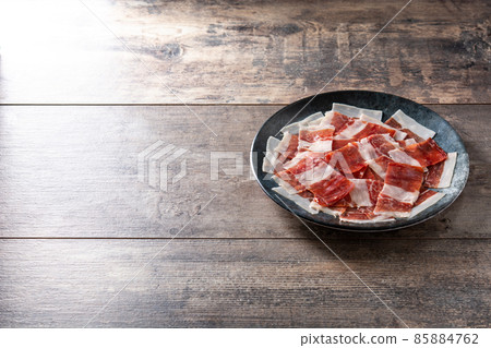 Spanish serrano ham slices on black plate Spanish serrano ham slices on black plate 85884762