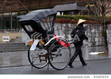 Part-time student pulling a rickshaw on the back road of Tenryu-ji Temple in Arashiyama, Kyoto 85885659