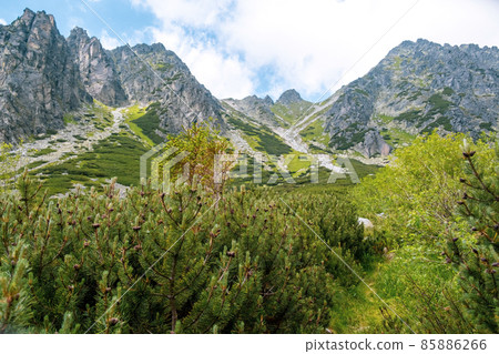 High Tatra mountains peak with the blue sky and clouds on the background in Slovakia. Tourist trails for hiking in summer High Tatra mountains peak with the blue sky and clouds on the background in Slovakia. Tourist trails for hiking in summer 85886266