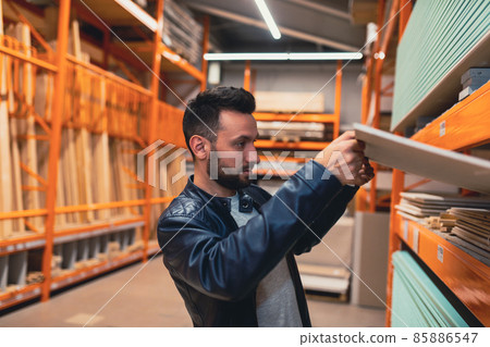 buyers a man in a hardware store chooses drywall for the construction of a new house buyers a man in a hardware store chooses drywall for the construction of a new house 85886547