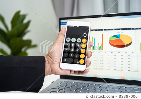 Asian accountant working and analyzing financial reports project accounting with chart graph and calculator in modern office, finance and business concept. 85887006