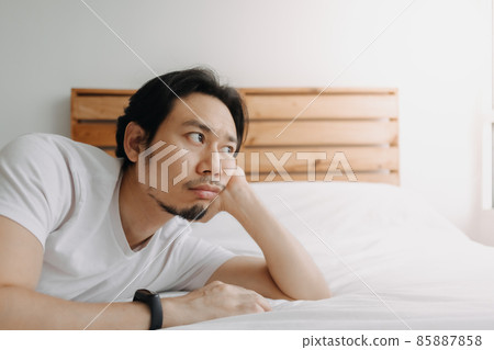 Exhausted man lay on the bed as he feels burnout. Exhausted man lay on the bed as he feels burnout. 85887858