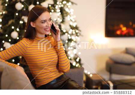 Cheerful woman talking on cellphone sitting on couch 85888312