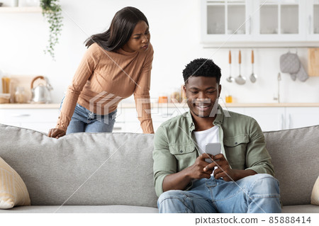 Angry black woman watching her boyfriend chatting with ladies Angry black woman watching her boyfriend chatting with ladies 85888414