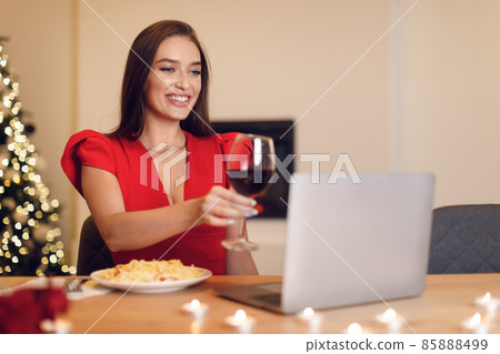 Excited woman having dinner during virtual date on laptop Excited woman having dinner during virtual date on laptop 85888499