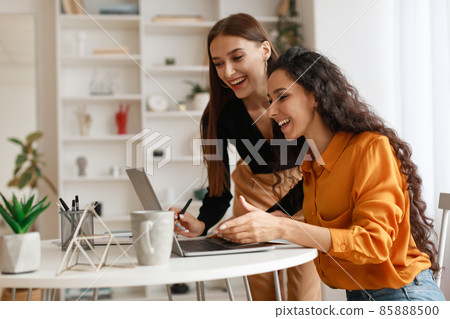 Two Happy Ladies Using Laptop Computer Working Online In Office Two Happy Ladies Using Laptop Computer Working Online In Office 85888500
