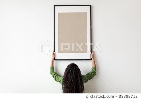 Unrecognizable Female Hanging Blank Poster In Frame On Wall Indoor Unrecognizable Female Hanging Blank Poster In Frame On Wall Indoor 85888712