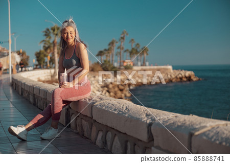 Sporty adult woman resting after training by the waterfront 85888741